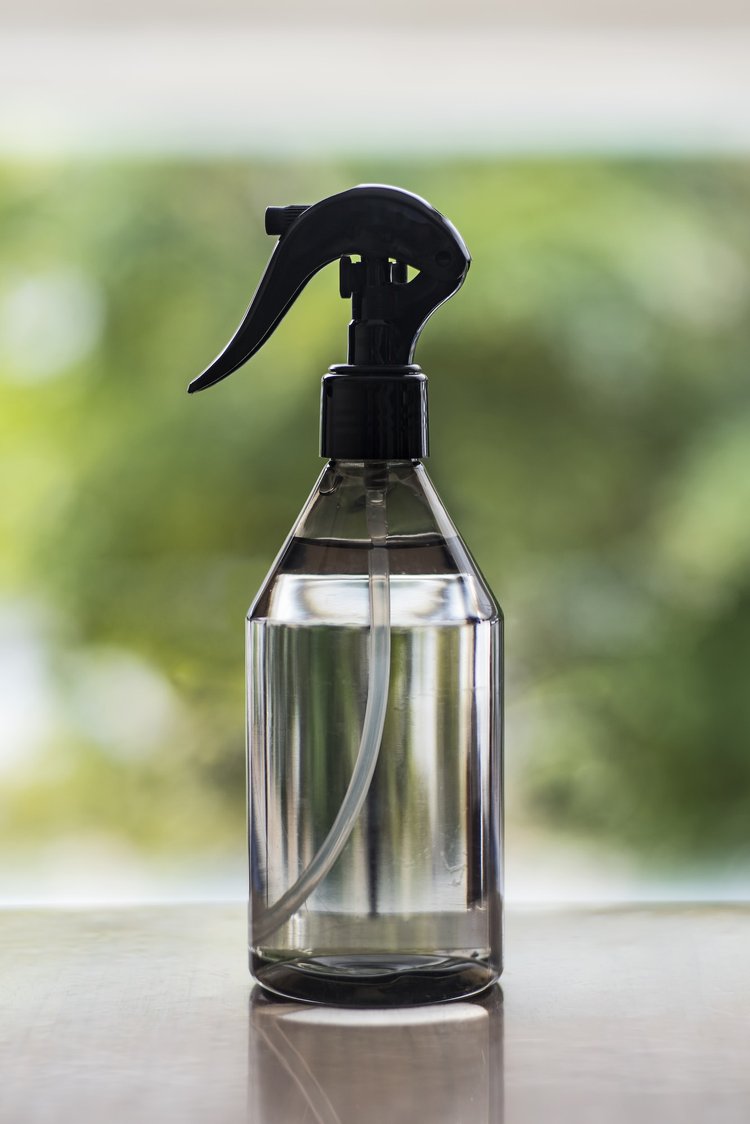 Clear spray bottle filled with water and essential oils