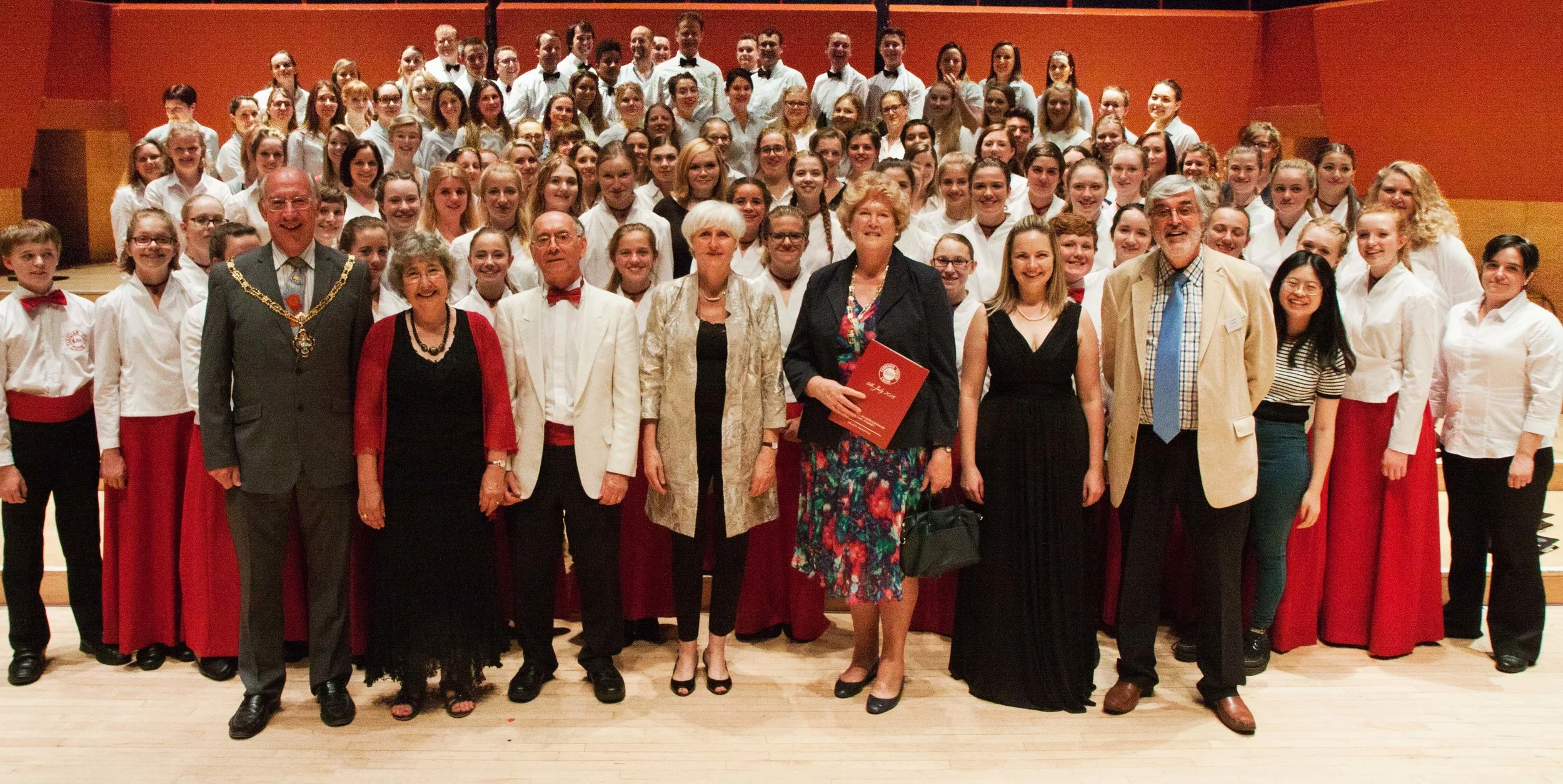Farnham Youth Choir & Alumni Choir stand alongside the founders David & Gillian Victor-Smith (second and third left), accompanist Julia Freeman (centre), Choral Director - Joanna Tomlinson (second right) and FYC Chairman, Graham Noakes (right) at the Celebration Concert, The Anvil Basingstoke - July 2016.