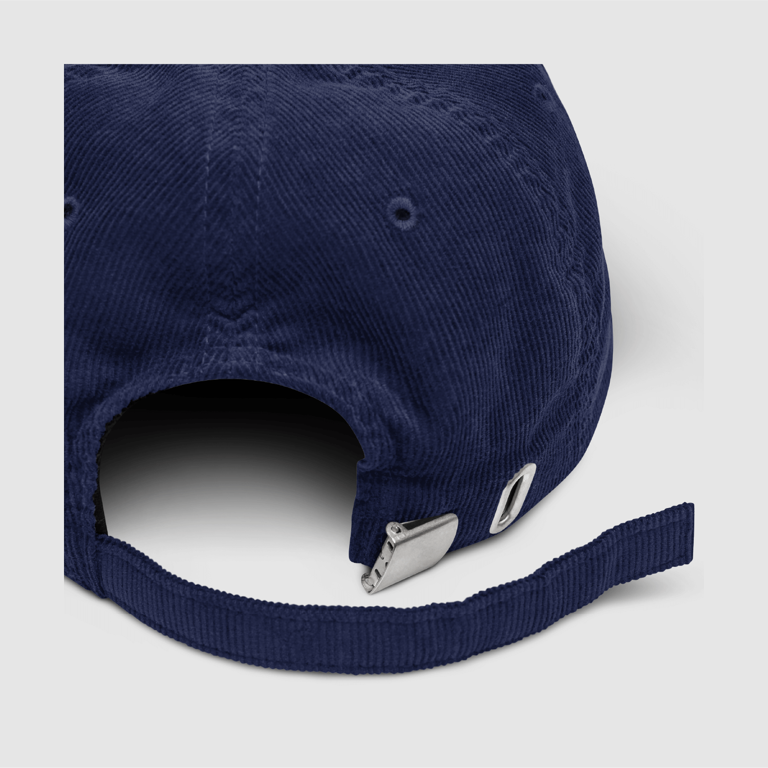 Close-up detail of the metal buckle and grommet on the navy strap