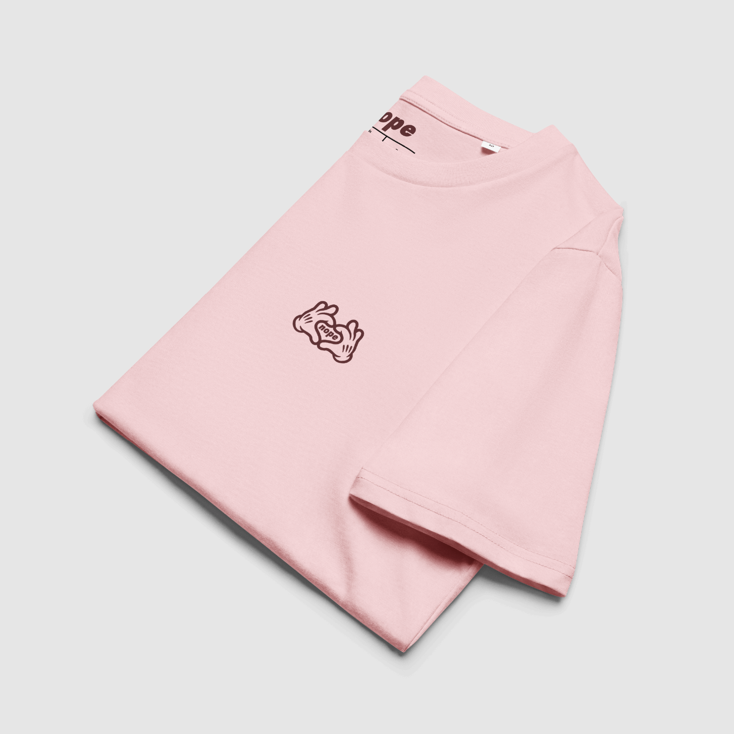 Folded pink tee with visible chest print and neck label