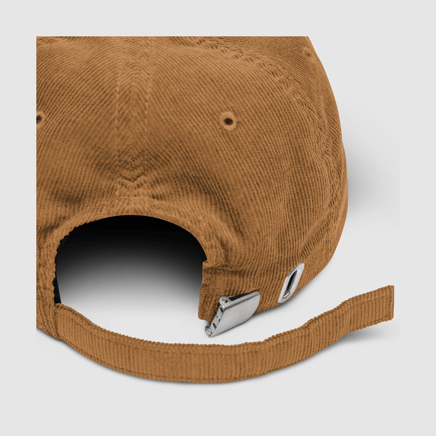 Detail close-up of the metal buckle and strap on the camel cord cap