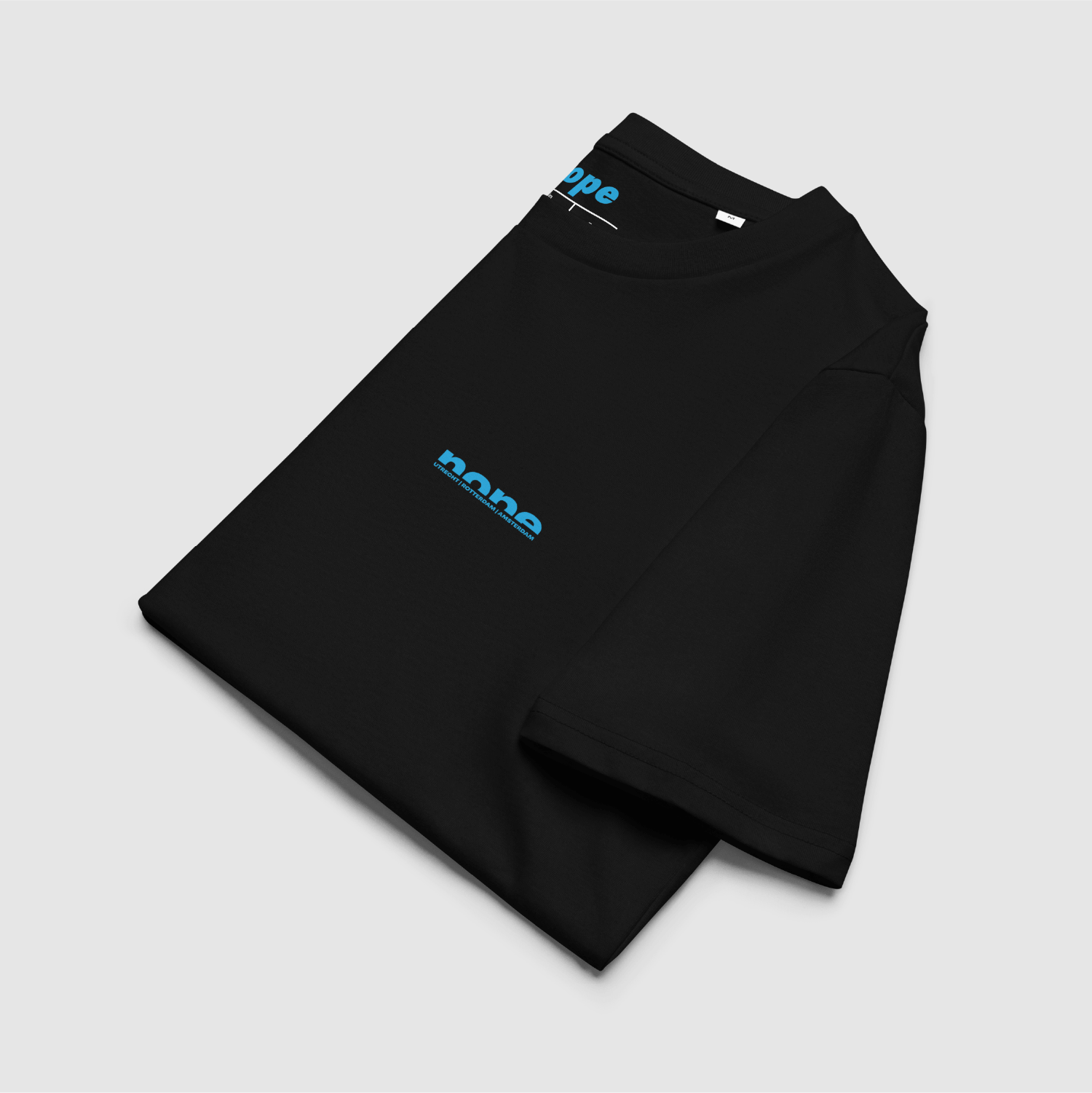 Folded black Nope T-shirt showing cyan chest and neck logos — designed by Mr. Nope for nopeshop.com