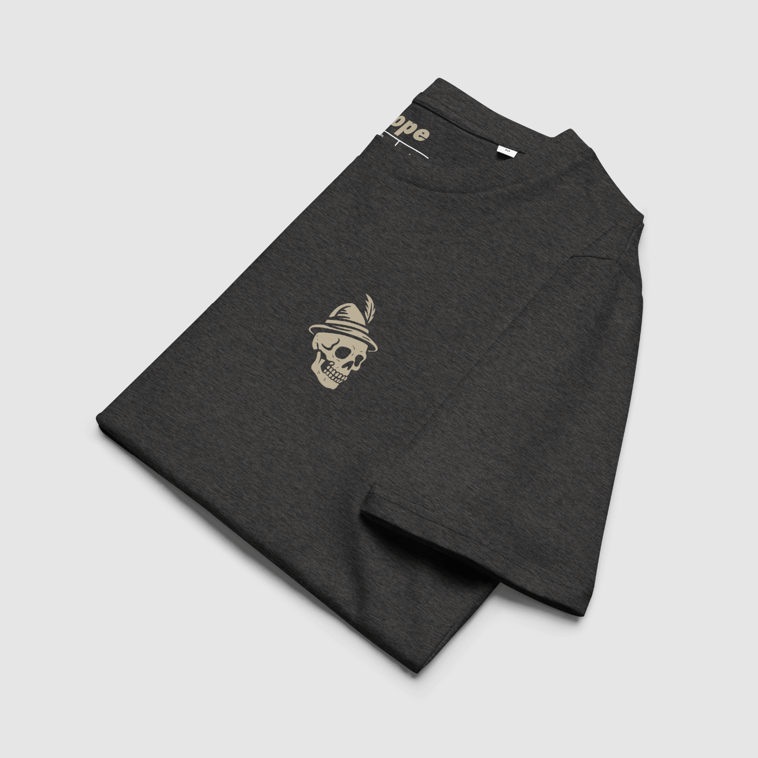 Folded Dark Heather Grey T-shirt showing left chest Alpine skull emblem in cream and internal Nope neck branding.