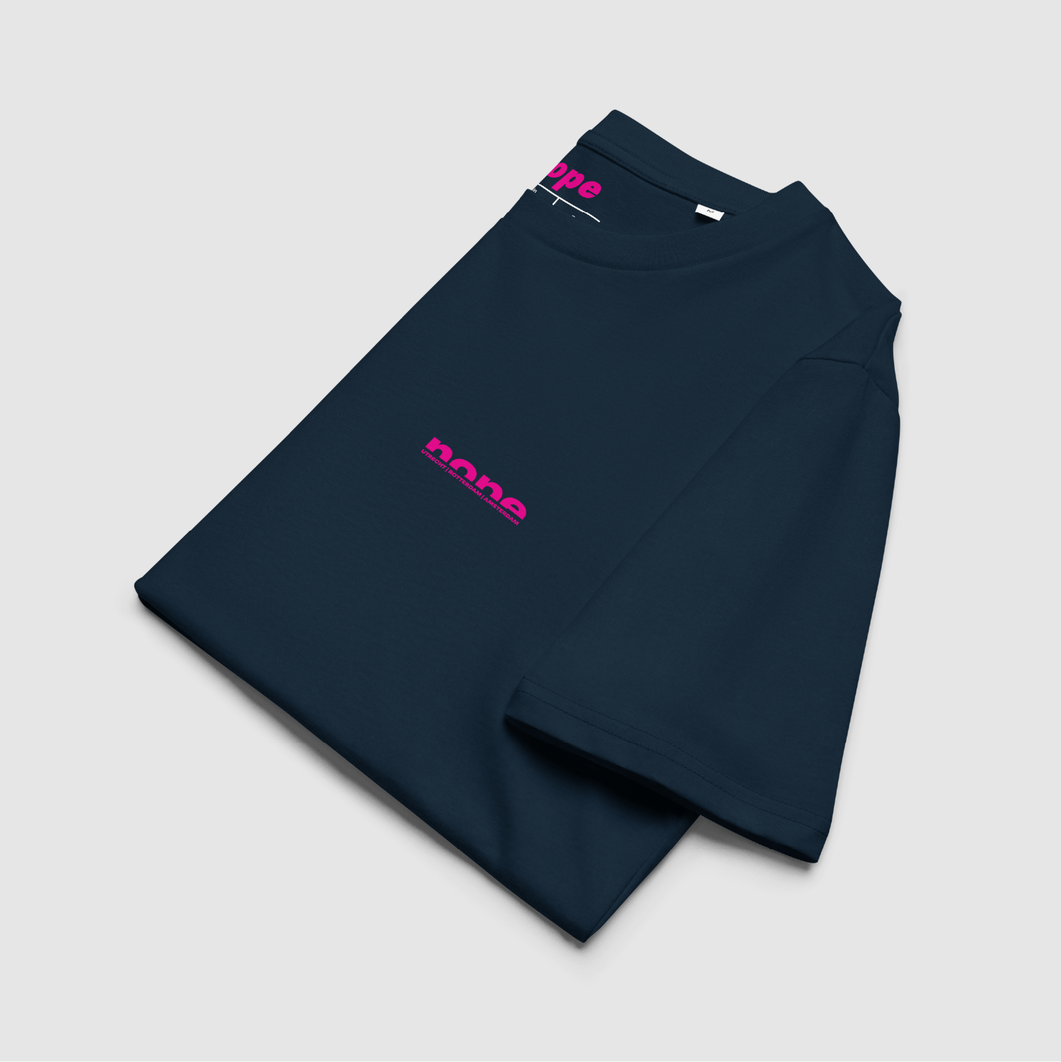 Folded navy Nope T-shirt showing chest and neck logos in bright pink — organic cotton streetwear