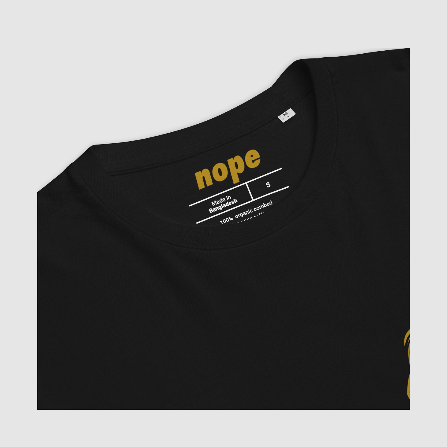 Close-up of the black Zero Fuchs T-Shirt inner neckline showing ochre “nope” brand print and sizing details.