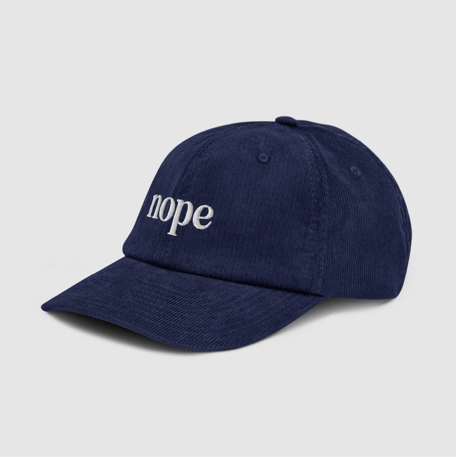 Angled front view of navy dad cap showing the embroidered “nope” logo and curved brim