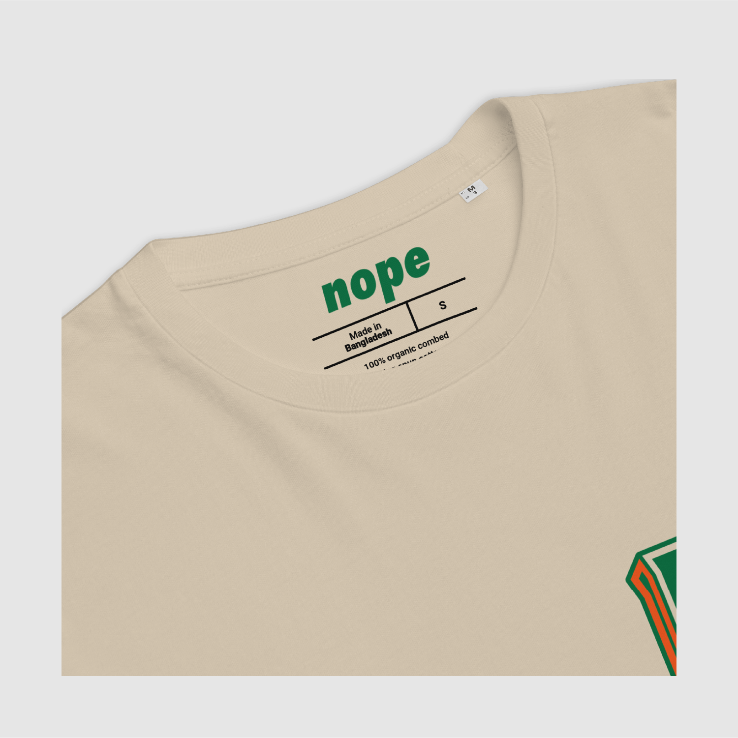 Inner neck detail of the Desert Dust Nope Tee – green print on beige Plain back view of the Desert Dust Nope 3D Logo Tee