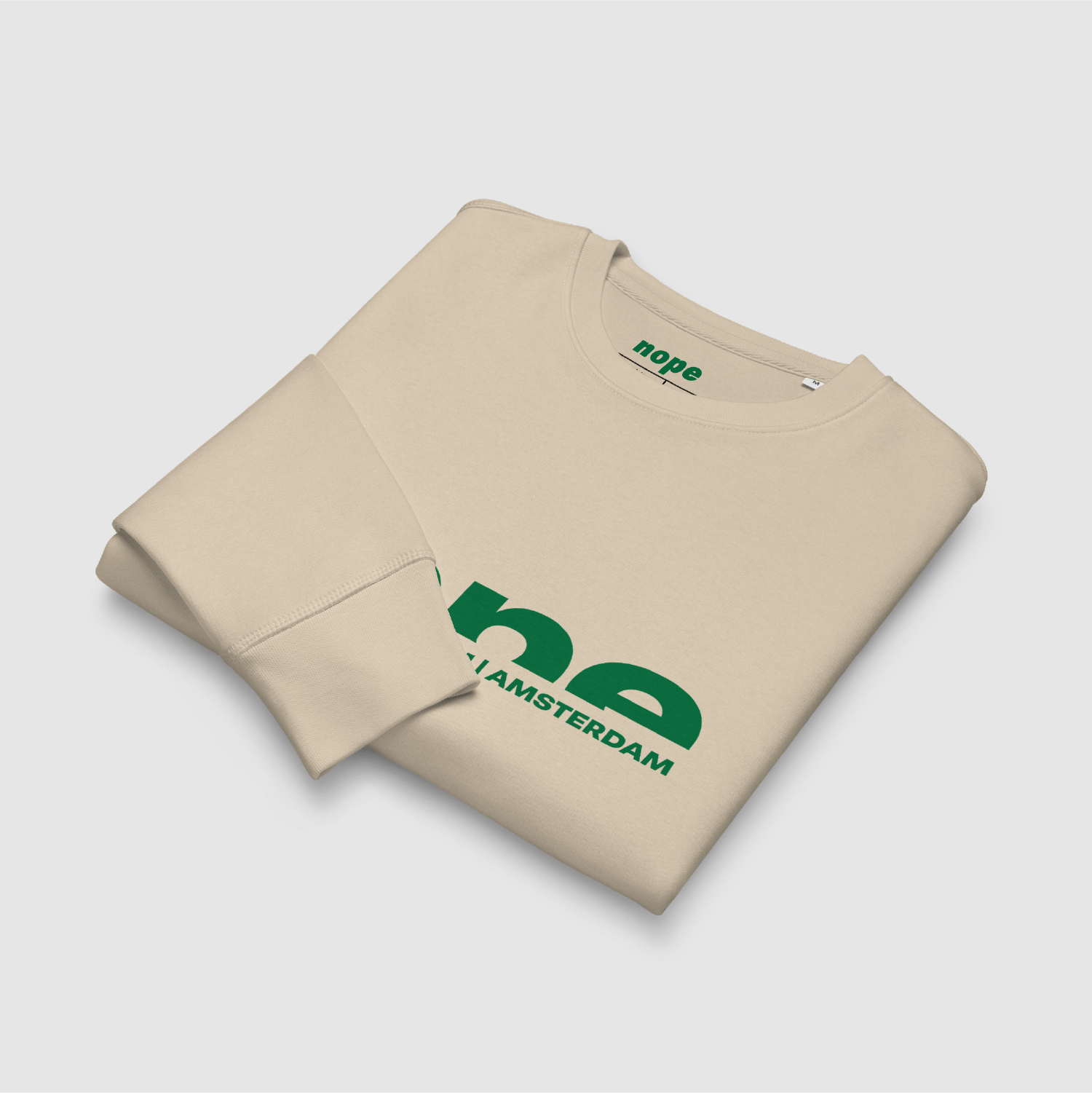 Folded desert beige sweatshirt with bold green Nope logo and city print – eco streetwear designed by Mr. Nope