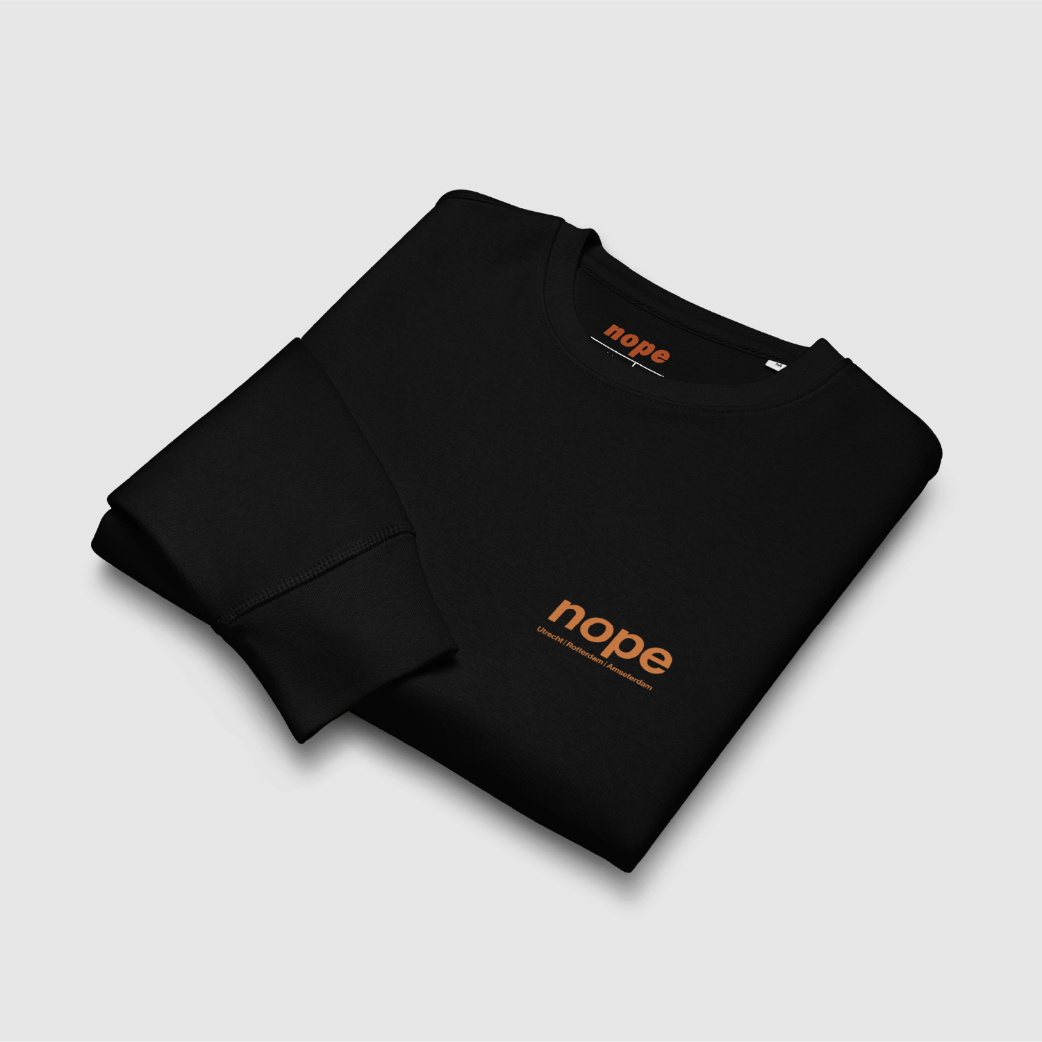 Folded View: Folded Nopehaus sweatshirt in black showing burnt orange chest logo – designed by Mr. Nope