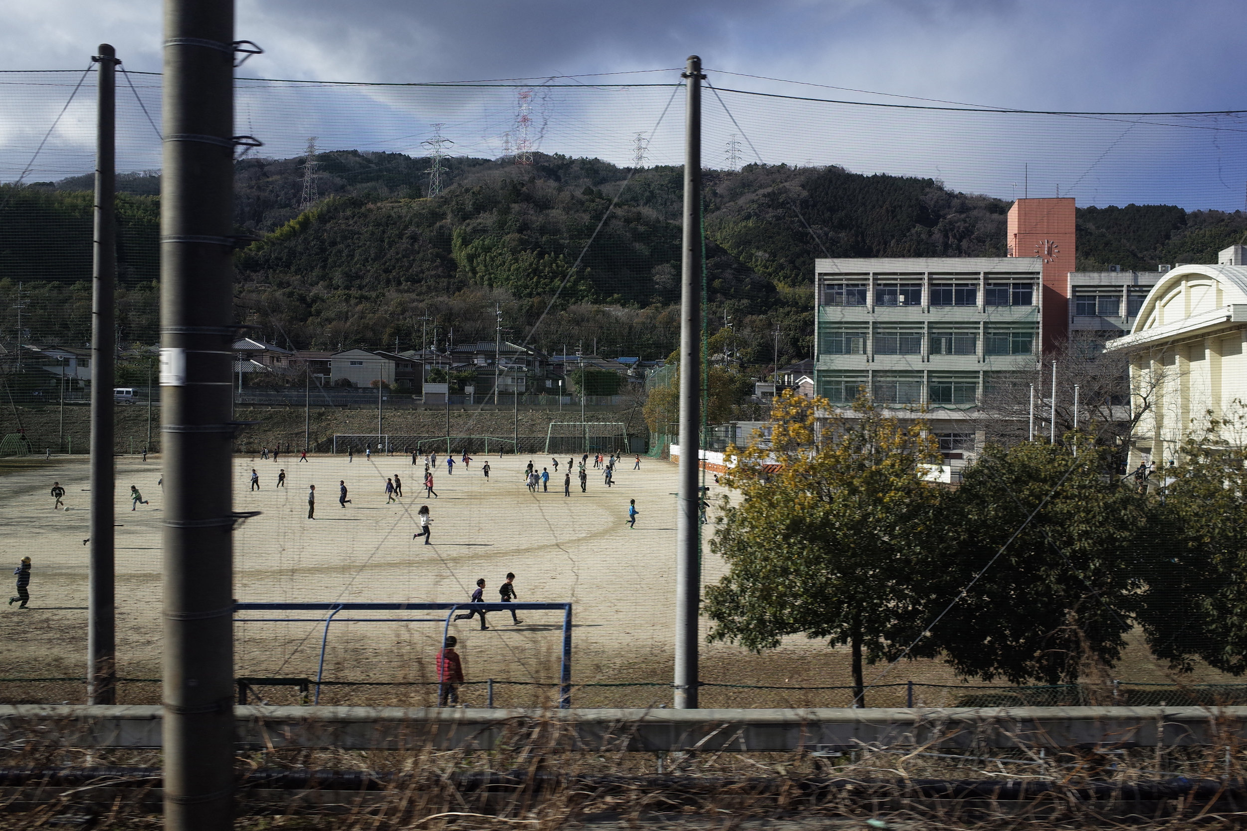  Schoolchildren at play in Shimamoto Choritsu Daisan Elementary School in Shimamoto, Osaka, Japan (Picture was taken from the window seat of an express train) 