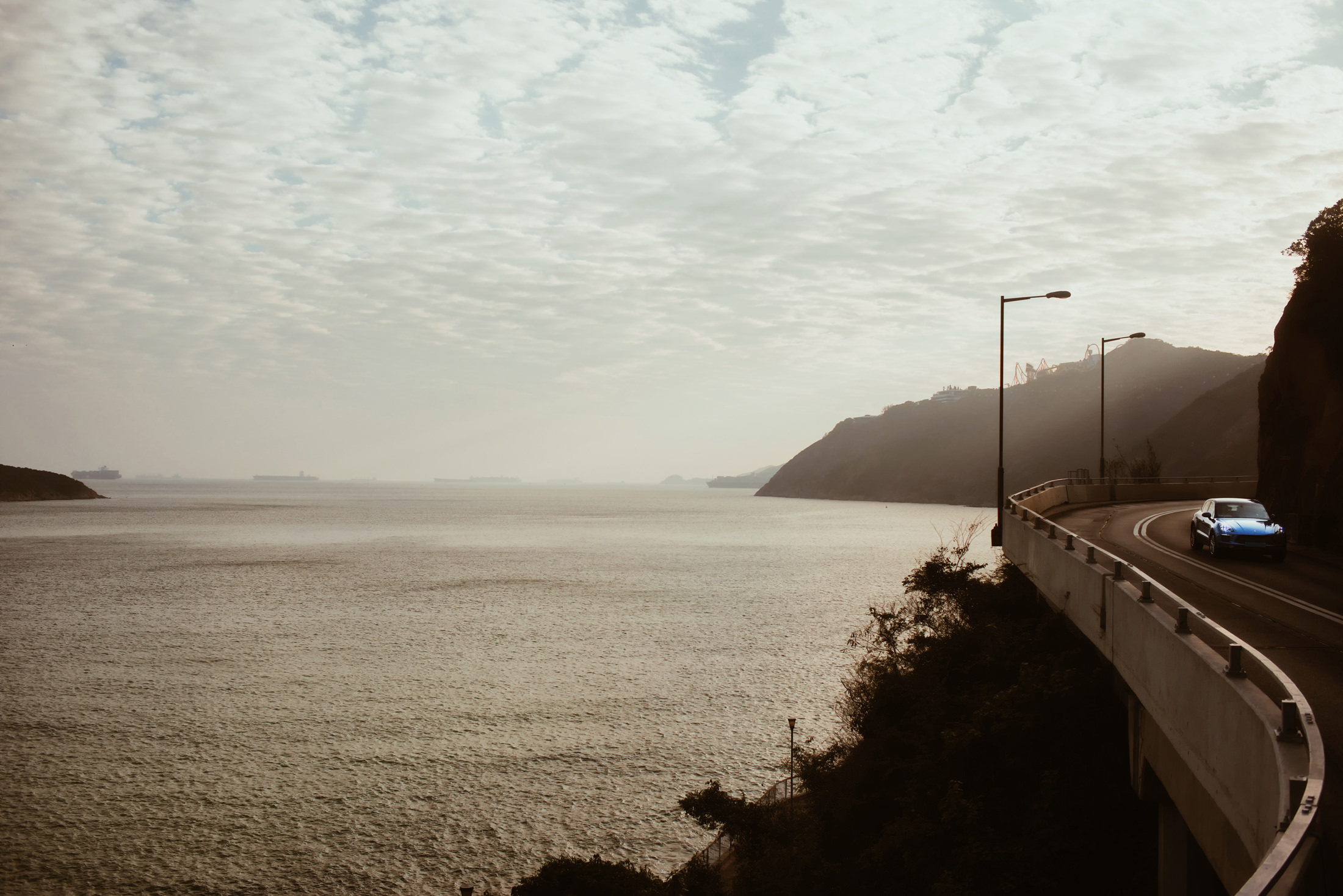  A Porsche Cayenne travels down a stretch of road at Deep Water Bay, Hong Kong island (Picture was taken off the window seat on the upper level of a double-decker bus)  