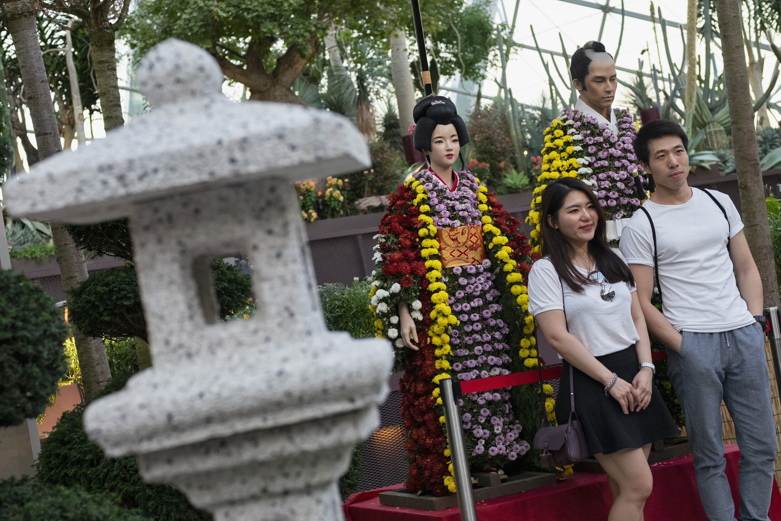  Visitors pose in front of mannequins dressed in chrysanthemums in the likeness of Japanese traditional attire during the Sakura Matsuri floral display at Gardens by the Bay in Singapore 