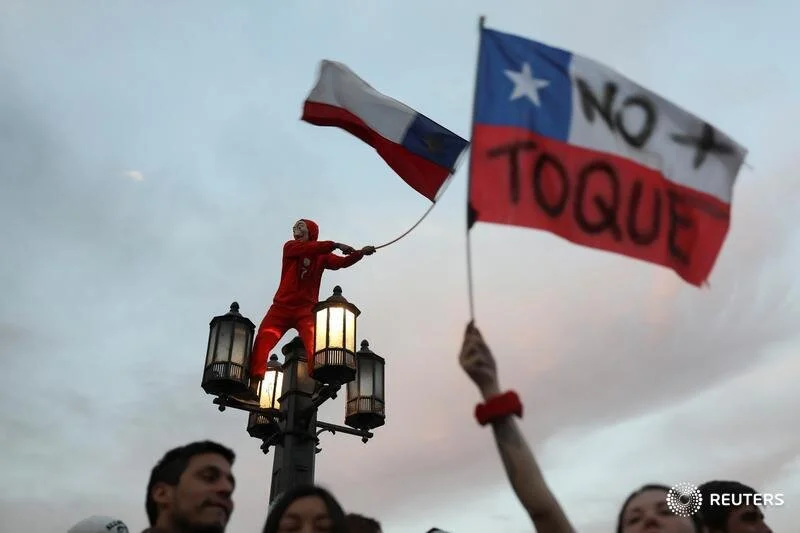  Demonstrators hold up Chilean flags during a protest against Chile's state economic model in Santiago, Chile October 25, 2019. REUTERS/Pablo Sanhueza 
