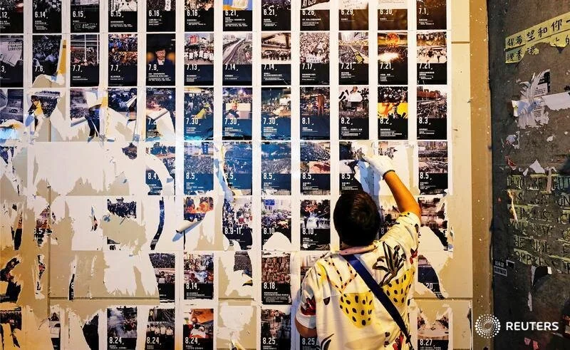  A pro-China supporter cleans up Lennon Walls of anti-government posters and memo notes outside Yuen Long MTR station in Hong Kong, China September 21, 2019. REUTERS/Tyrone Siu     