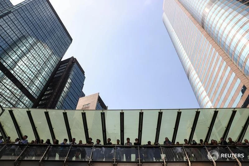  Office workers watch anti-government demonstrators block a road during a protest in Central, Hong Kong, China November 14, 2019. REUTERS/Athit Perawongmetha  