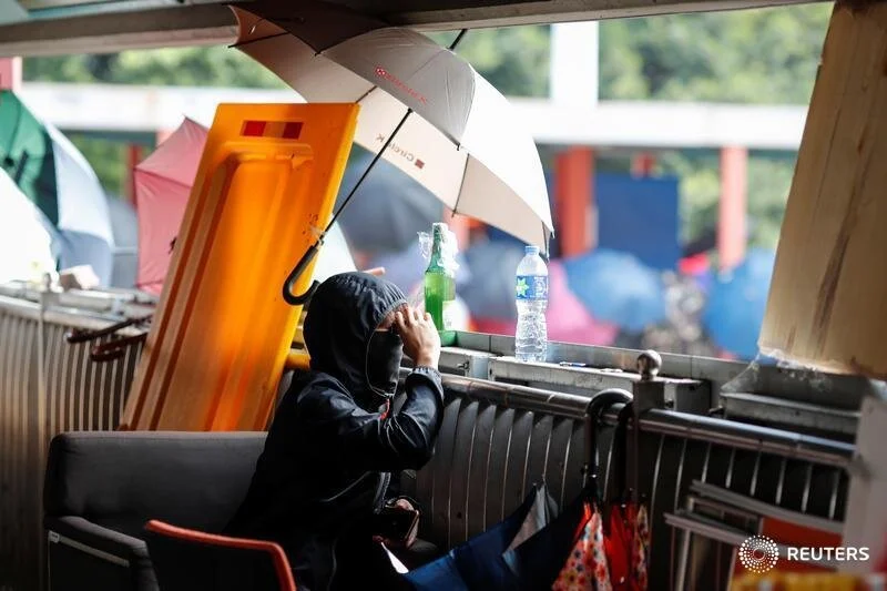  An anti-government demonstrator uses binoculars to keep an eye during protests at the Polytechnic University in Hong Kong, China, November 16, 2019. REUTERS/Adnan Abidi  