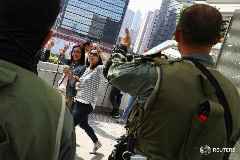  Pro-government supporters and a riot policeman flash thumbs up during a rally in Hong Kong, China, November 16, 2019. REUTERS/Athit Perawongmetha  