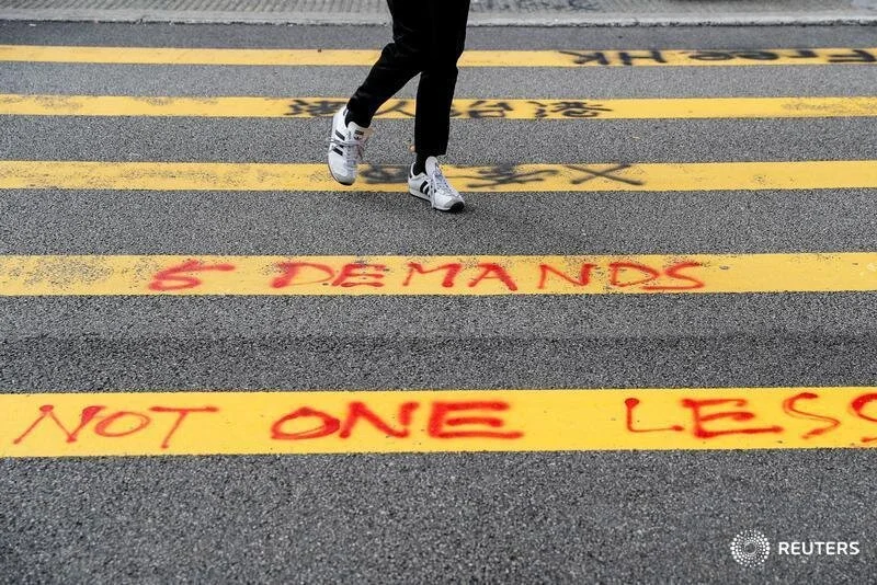  A pedestrian walks over graffiti on a crossing in Tsuen Wan, Hong Kong, China, October 2, 2019. REUTERS/Susana Vera 