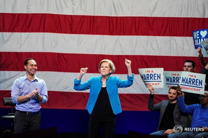  Democratic U.S. presidential candidate and Senator Elizabeth Warren reacts between former Democratic U.S. presidential candidate Julian Castro and supporters during her campaign event at Brooklyn's Kings Theatre in New York, January 7, 2020. REUTERS