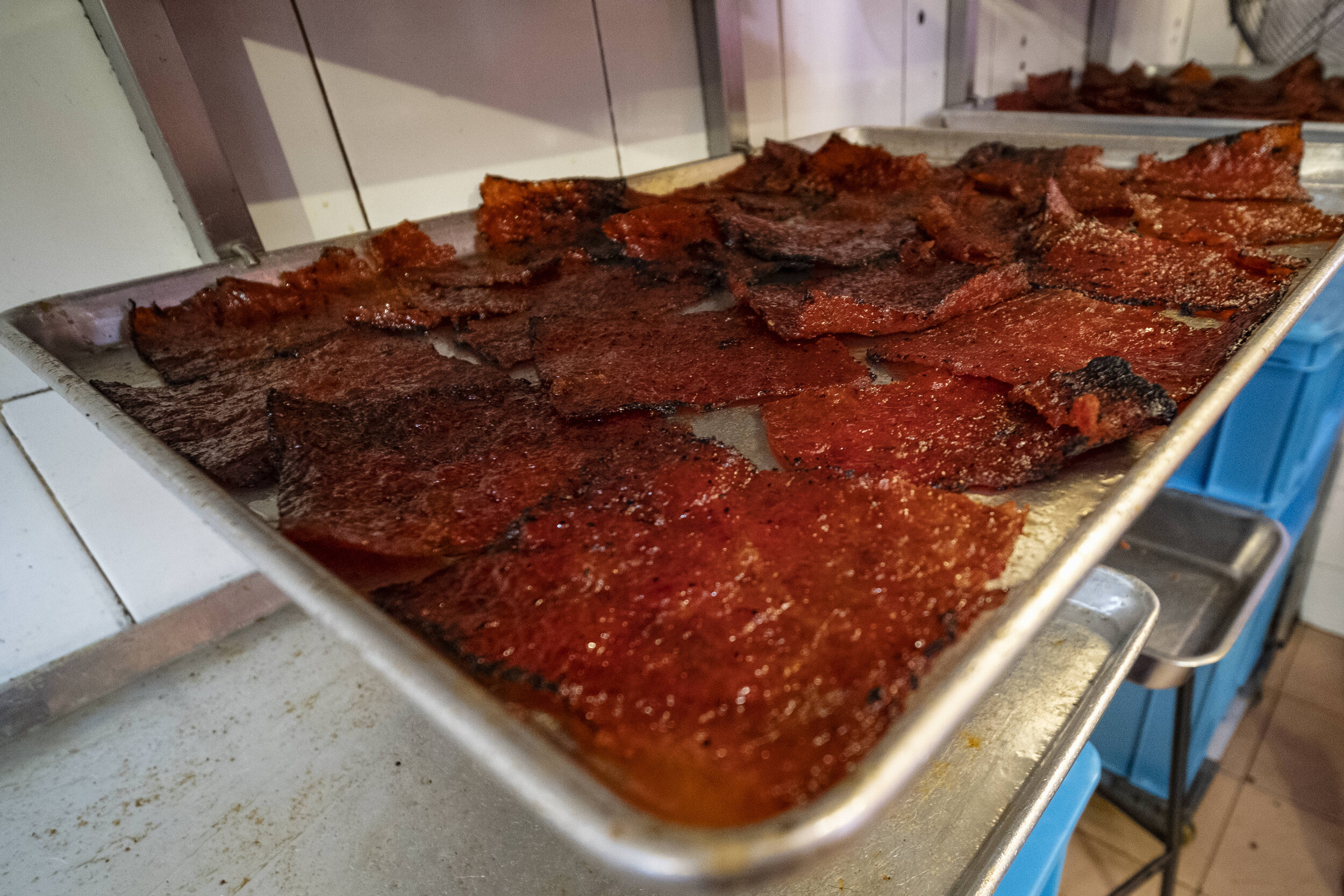  Freshly grilled Bak Kwa sit on trays to cool at the back of the stall 