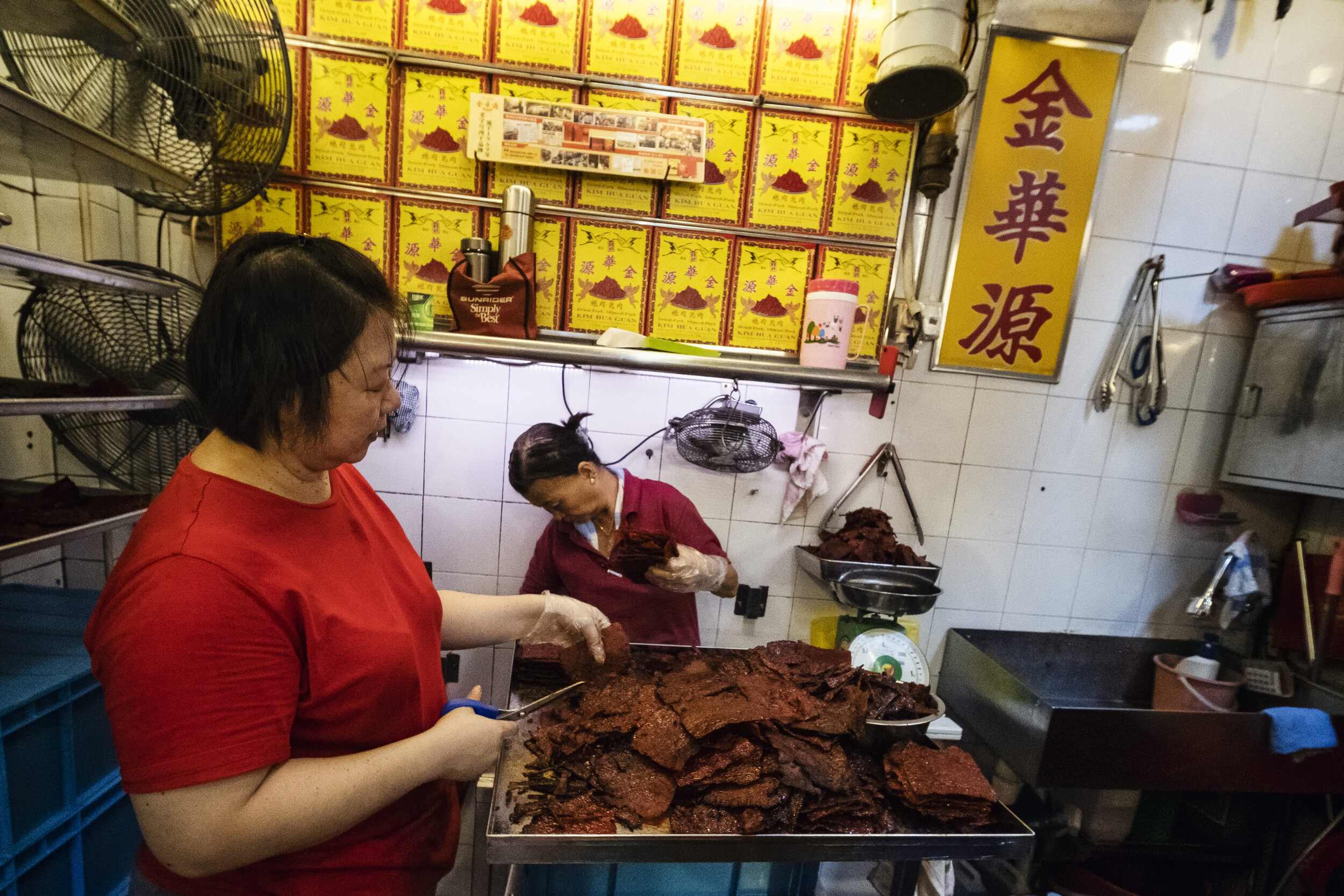  Employees at the back of the stall trim off charred edges of Bak Kwa as they work in the heat and confines of the tight space 