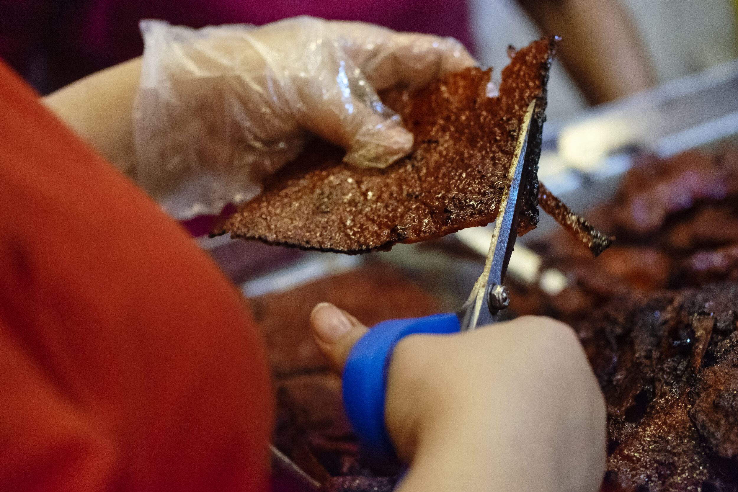  An employee carefully trims off a charred edge on a slice of Bak Kwa before it gets packed for sale 
