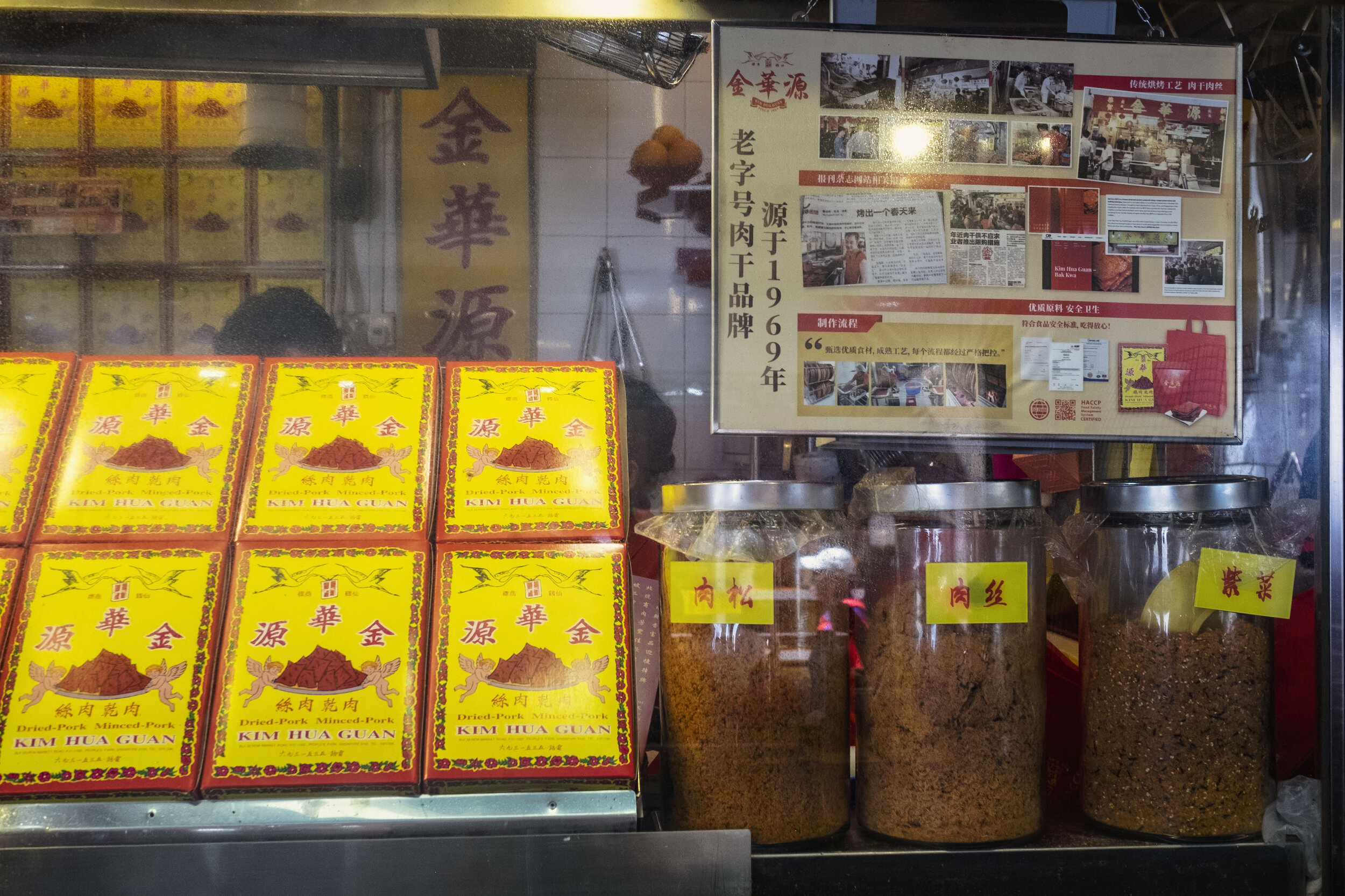  Jars of various types of meat floss and boxes for Bak Kwa are displayed at the front of the stall 