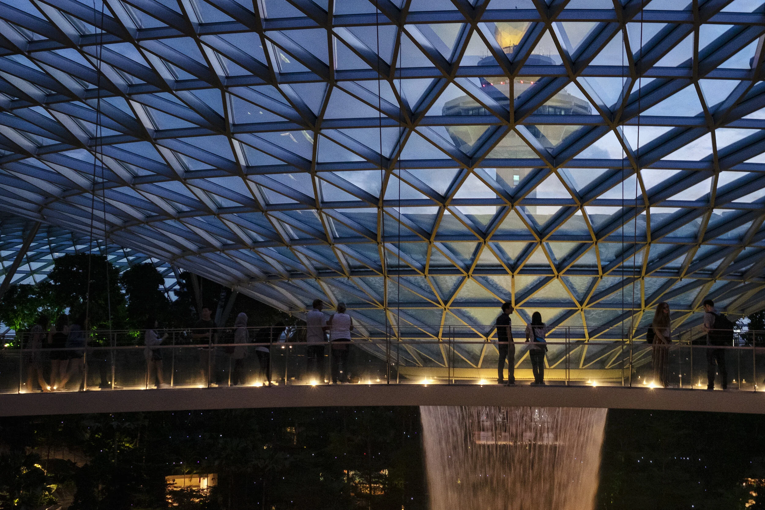  People view the Rain Vortex indoor waterfall from a glass-bottomed bridge at Jewel Changi Airport in Singapore 