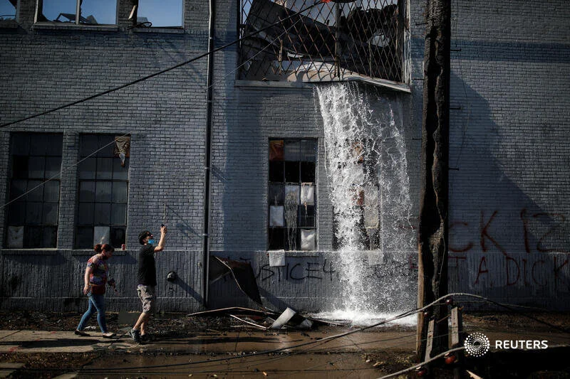  Water gushes out a building that was burnt down during protests last night in the aftermath of a white police officer caught on a bystander's video pressing his knee into the neck of African-American man George Floyd, who later died at a hospital, i