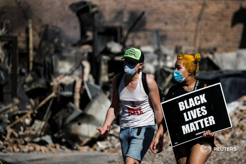 Protesters wearing face masks walk with a Black Life Matters sign after a white police officer was caught on a bystander's video pressing his knee into the neck of African-American man George Floyd, who later died at a hospital, in Minneapolis, Minn