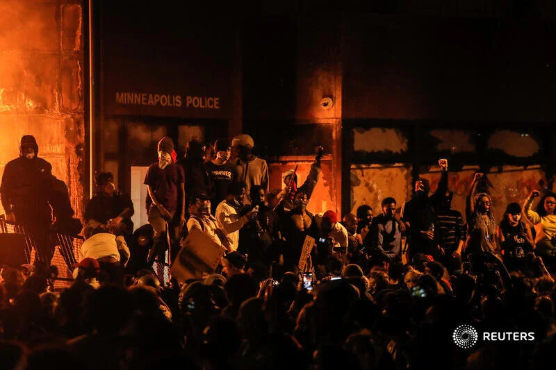  Protesters gather around after setting fire to the entrance of a police station as demonstrations continue after a white police officer was caught on a bystander's video pressing his knee into the neck of African-American man George Floyd, who later