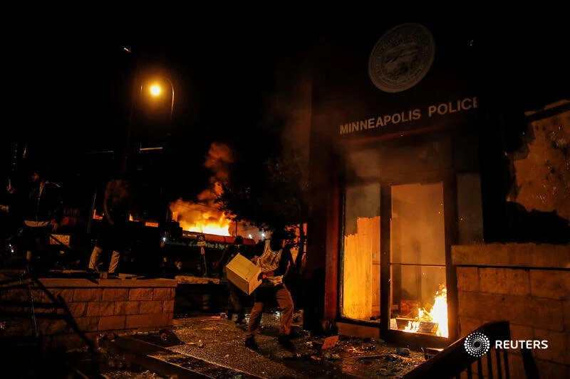  A protester sets fire to the entrance of a police station as demonstrations continue after a white police officer was caught on a bystander's video pressing his knee into the neck of African-American man George Floyd, who later died at a hospital, i