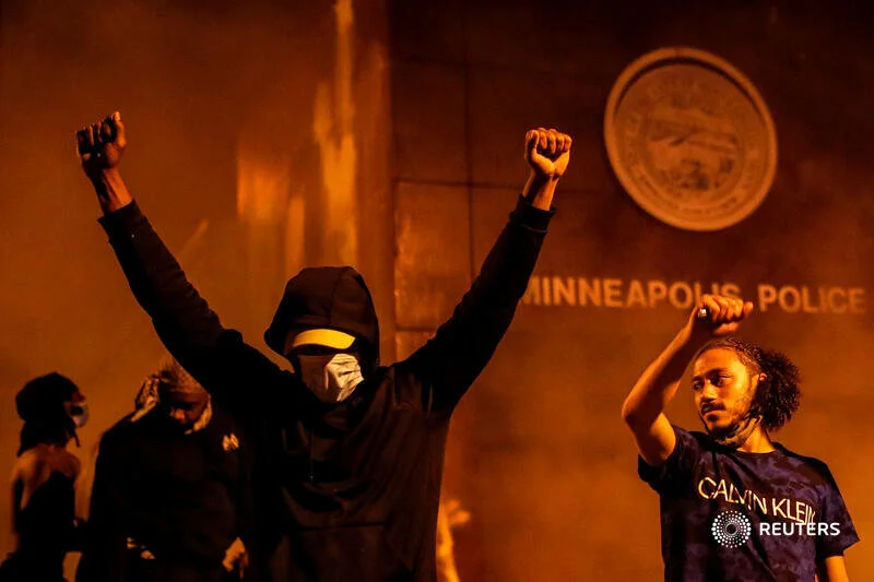  Protesters react after setting fire to the entrance of a police station as demonstrations continue after a white police officer was caught on a bystander's video pressing his knee into the neck of African-American man George Floyd, who later died at