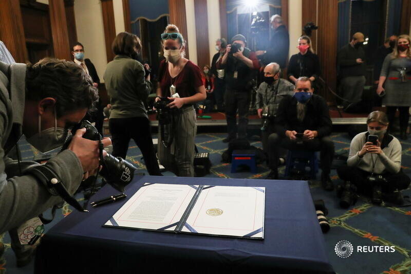  A member of the media takes photographs of the article of impeachment against U.S. President Donald Trump, which U.S. House Speaker Nancy Pelosi (D-CA) will sign in an engrossment ceremony, at the U.S. Capitol in Washington January 13, 2021. REUTERS