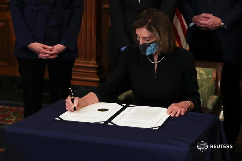  U.S. House Speaker Nancy Pelosi (D-CA) signs the article of impeachment against U.S. President Donald Trump in an engrossment ceremony, at the U.S. Capitol in Washington January 13, 2021. REUTERS/Leah Millis 