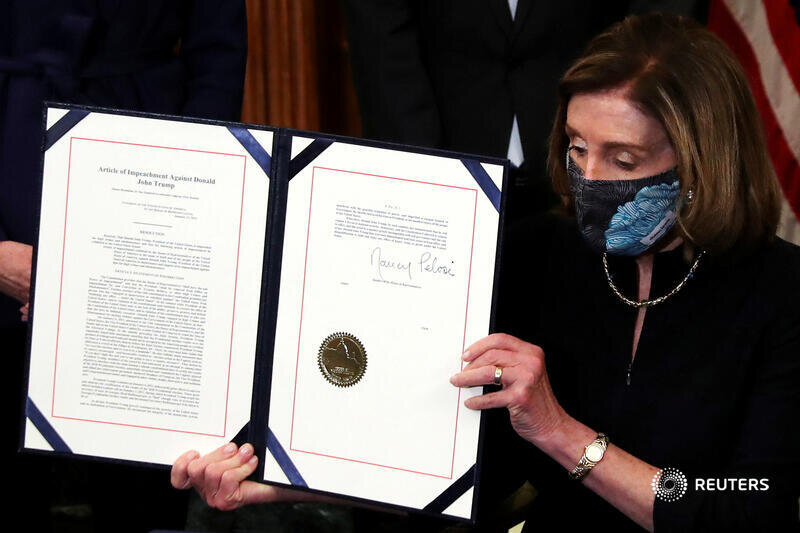  U.S. House Speaker Nancy Pelosi (D-CA) shows the article of impeachment against U.S. President Donald Trump after signing it in an engrossment ceremony, at the U.S. Capitol in Washington January 13, 2021. REUTERS/Leah Millis 
