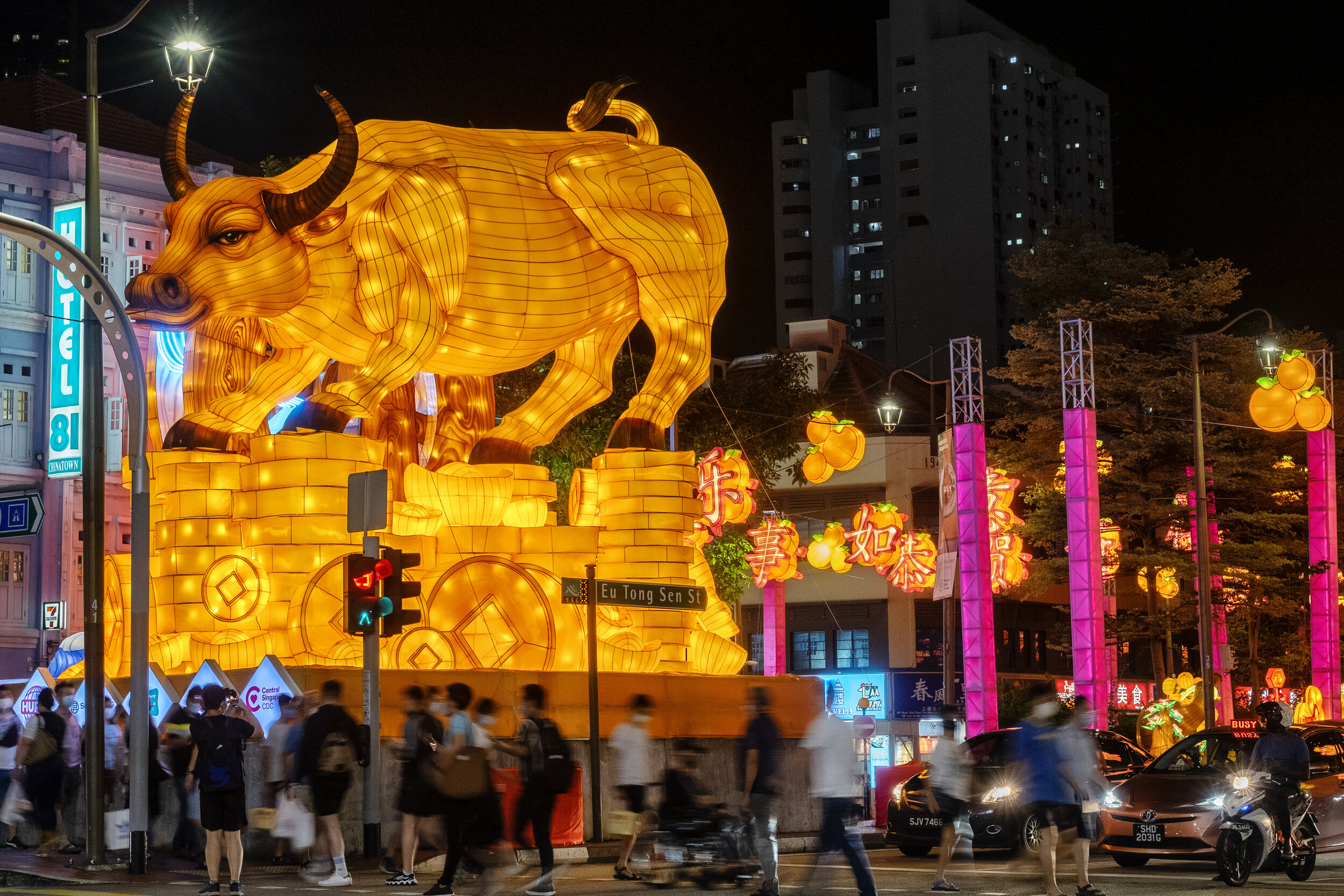  Pedestrians walk past a light sculpture of an ox at a road crossing ahead of the Chinese Lunar New Year of the Ox, otherwise known as the Spring Festival, in Singapore's Chinatown, January 31, 2021. Picture taken with long exposure. REUTERS/Loriene 