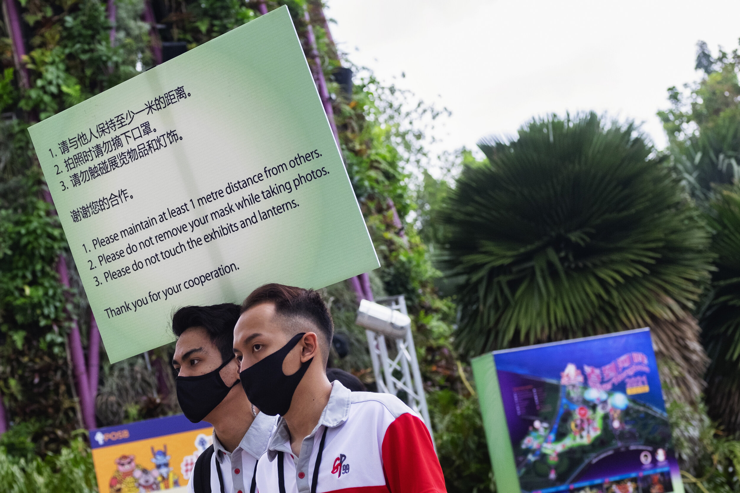  Event marshals carry a sign to remind visitors to comply with measures to curb the coronavirus disease (COVID-19) outbreak during the annual River Hongbao festival on the eve of the Chinese Lunar New Year of the Ox, otherwise known as the Spring Fes