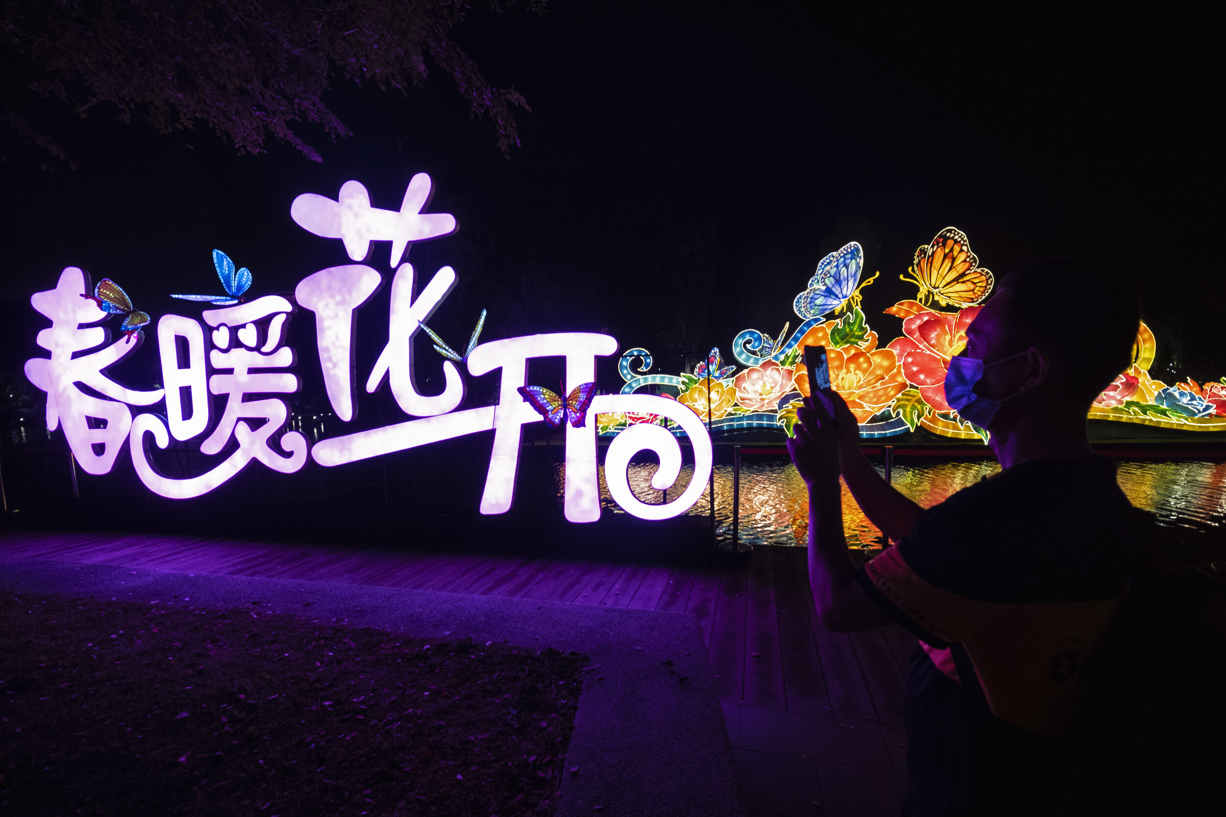  A visitor wearing a face mask takes pictures of lantern displays during the annual River Hongbao festival on the eve of the Chinese Lunar New Year of the Ox, otherwise known as the Spring Festival, at Singapore's Gardens by the Bay, February 11, 202