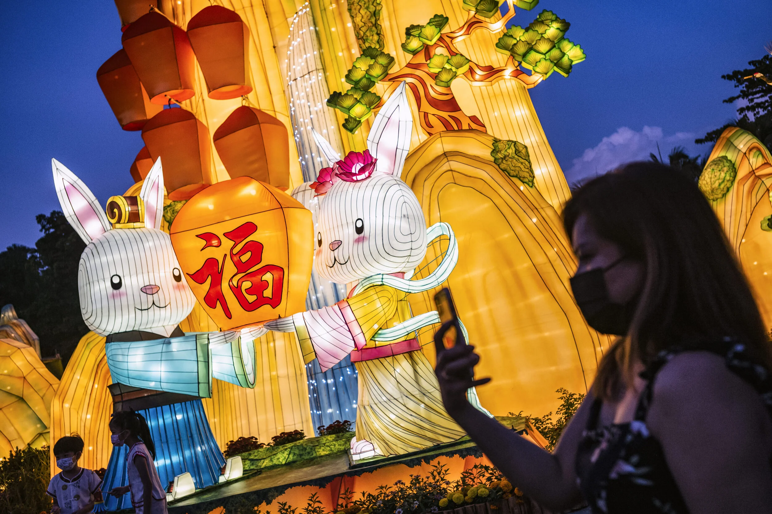  People take pictures around a rabbit-themed light sculpture during the Mid-Autumn Festival at Gardens by the Bay in Singapore 