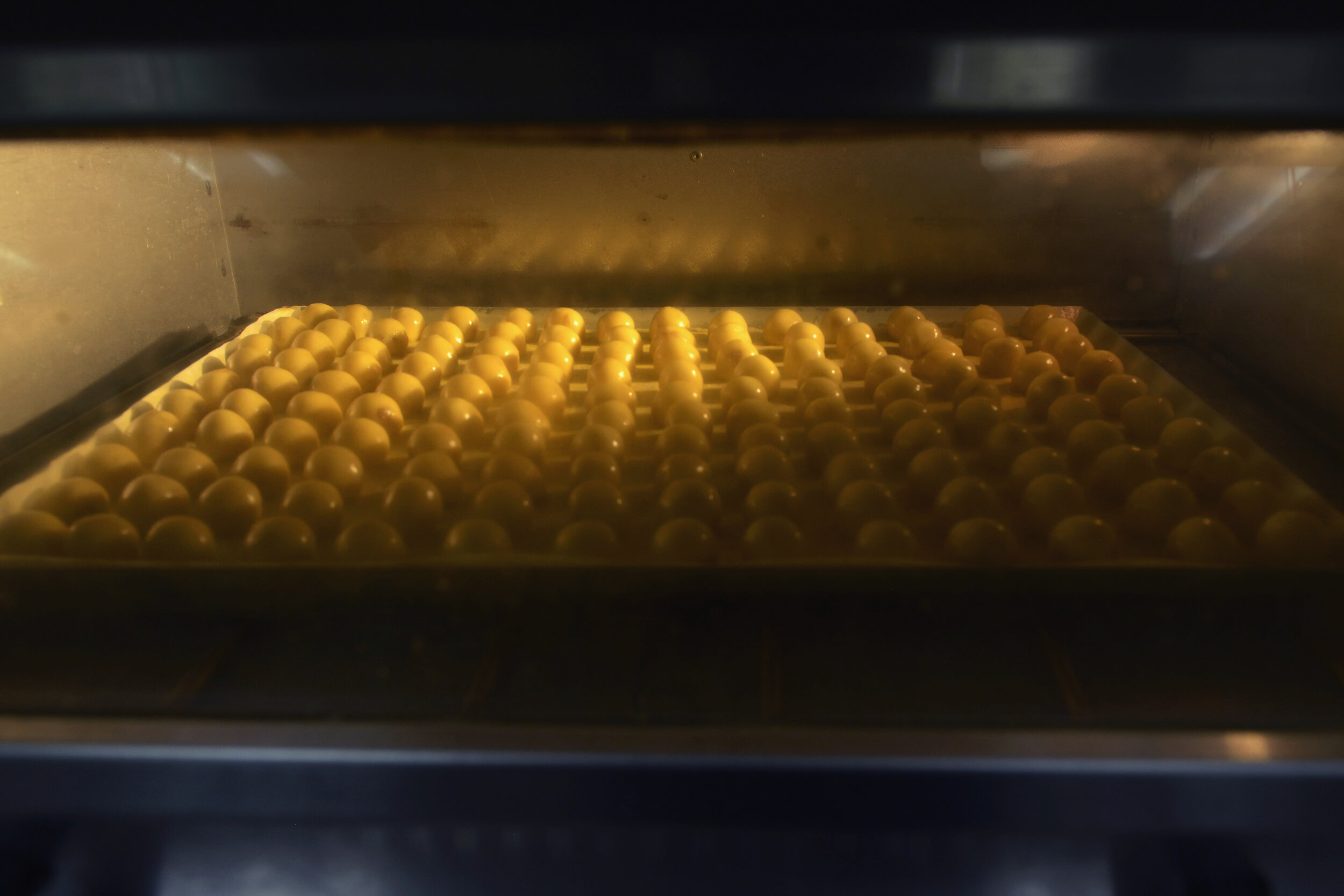   Pineapple tarts sit in an oven at the central kitchen of traditional Peranakan confectionery HarriAnns in Singapore April 20, 2018. 