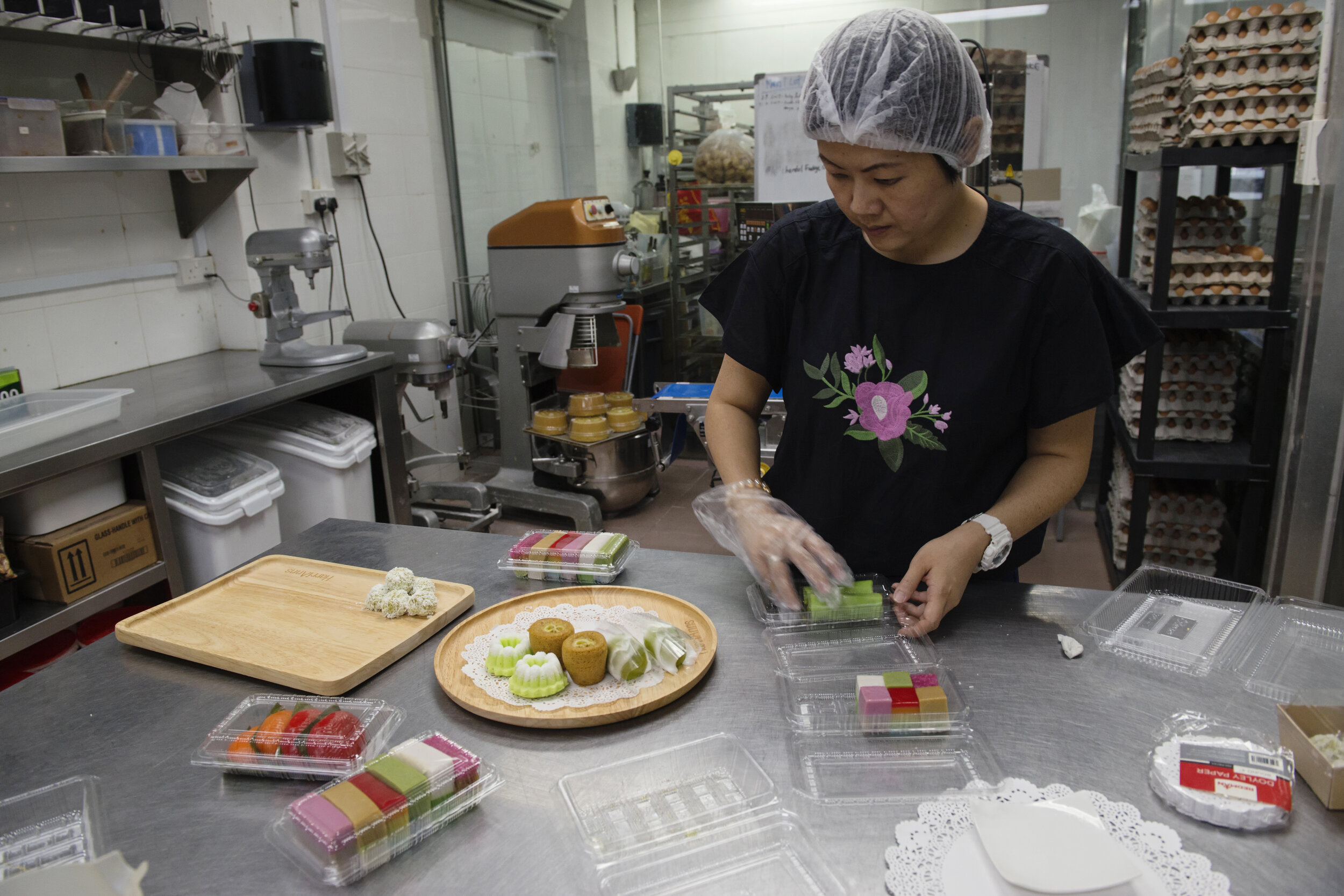  Sharon Goh, third-generation co-owner of traditional Peranakan confectionery HarriAnns, plates an assortment of Nonya kueh at their central kitchen in Singapore April 20, 2018.  