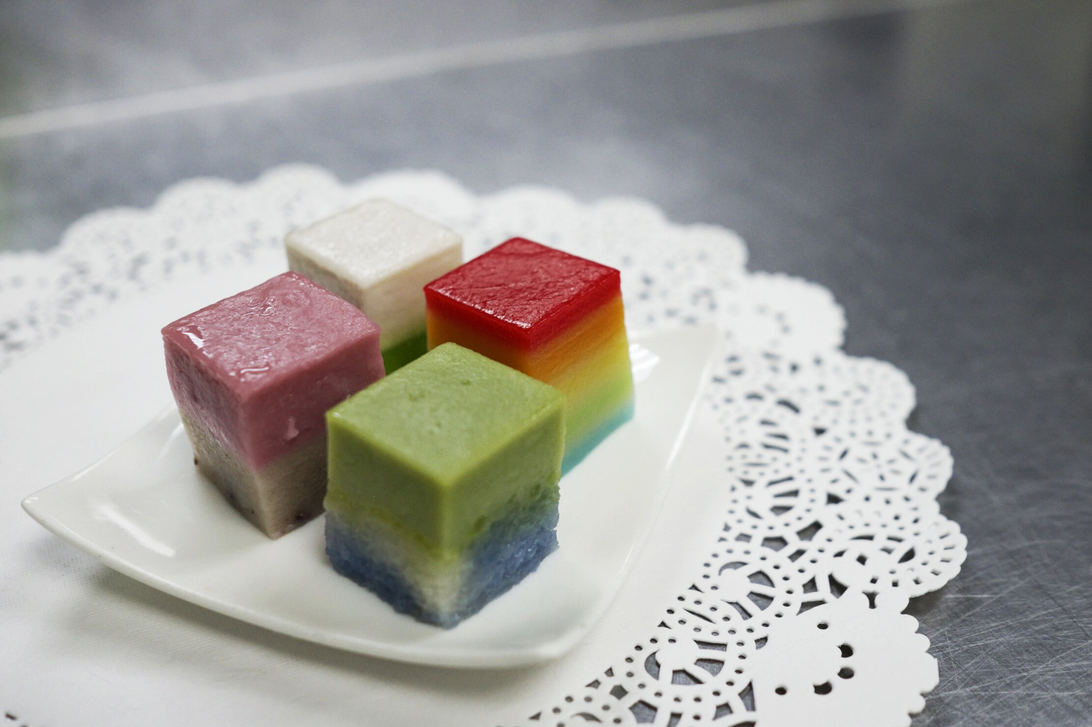  A plate of Nonya kueh is seen at the central kitchen of traditional Peranakan confectionery HarriAnns in Singapore April 20, 2018. Pictured clockwise are kueh talum, rainbow lapis, kueh salat and pink fairy.  