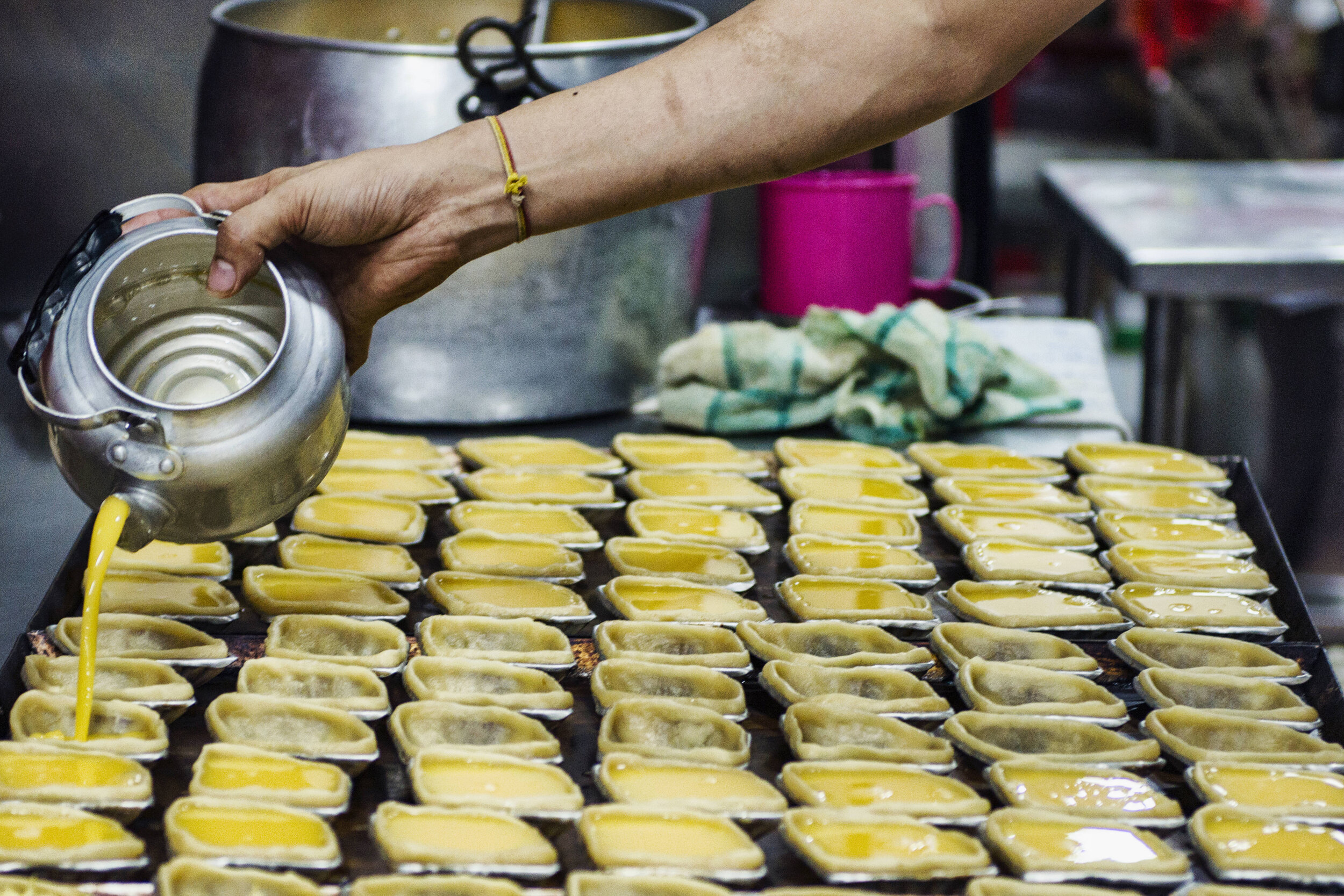  An employee pours custard filling into tart cases before baking egg tarts at the traditional Cantonese confectionery Tong Heng in Singapore April 21, 2018. 