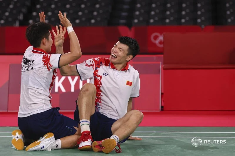  Tokyo 2020 Olympics - Badminton - Mixed Doubles - Gold medal match - MFS - Musashino Forest Sport Plaza, Tokyo, Japan – July 30, 2021. Wang Yilyu and Huang Dongping of China celebrate after winning gold in the match against Zheng Siwei of China and 