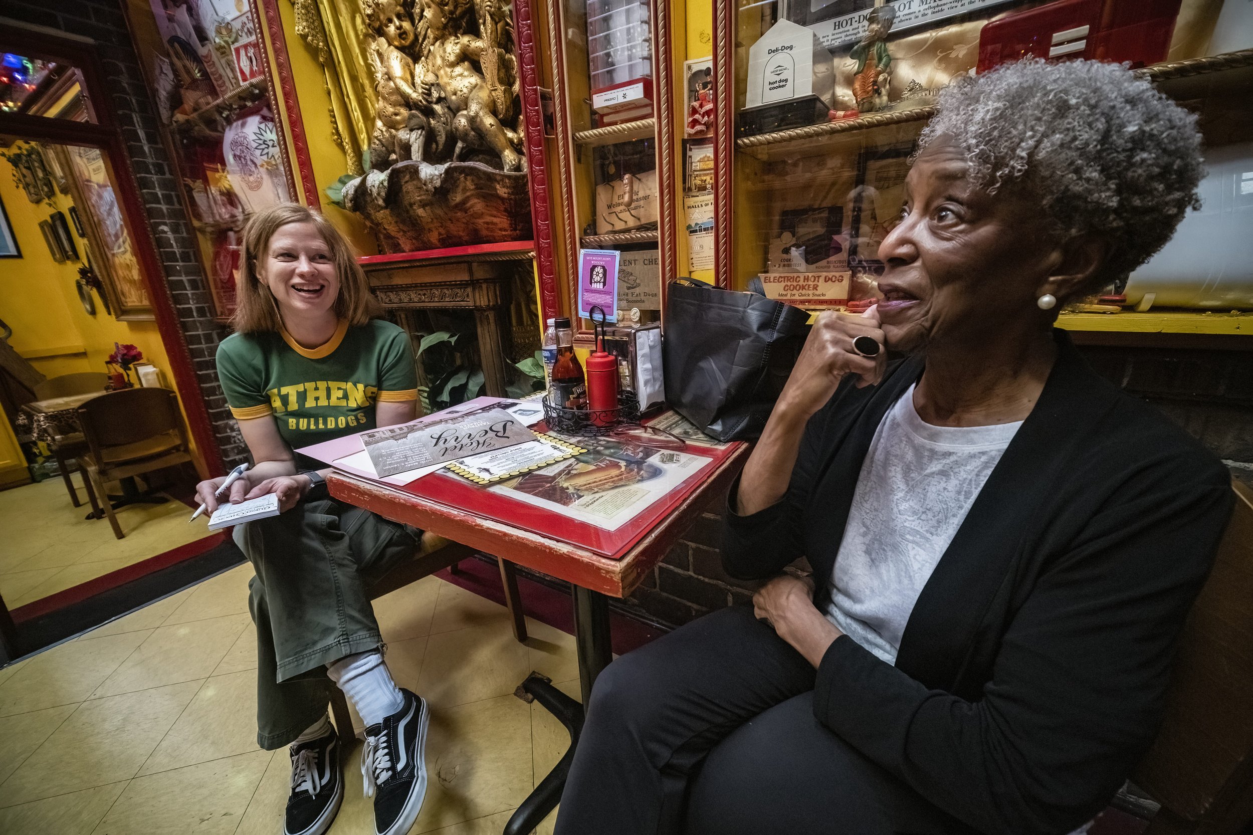  Dr. Tee Ford-Ahmed checks out the interior decor of O'Betty's Red Hot, a local restaurant that specializes in hot dogs, as she speaks to manager Tracy Duncan in Athens, Ohio, Wednesday, April 5, 2023. According to Mount Zion Baptist Church Preservat