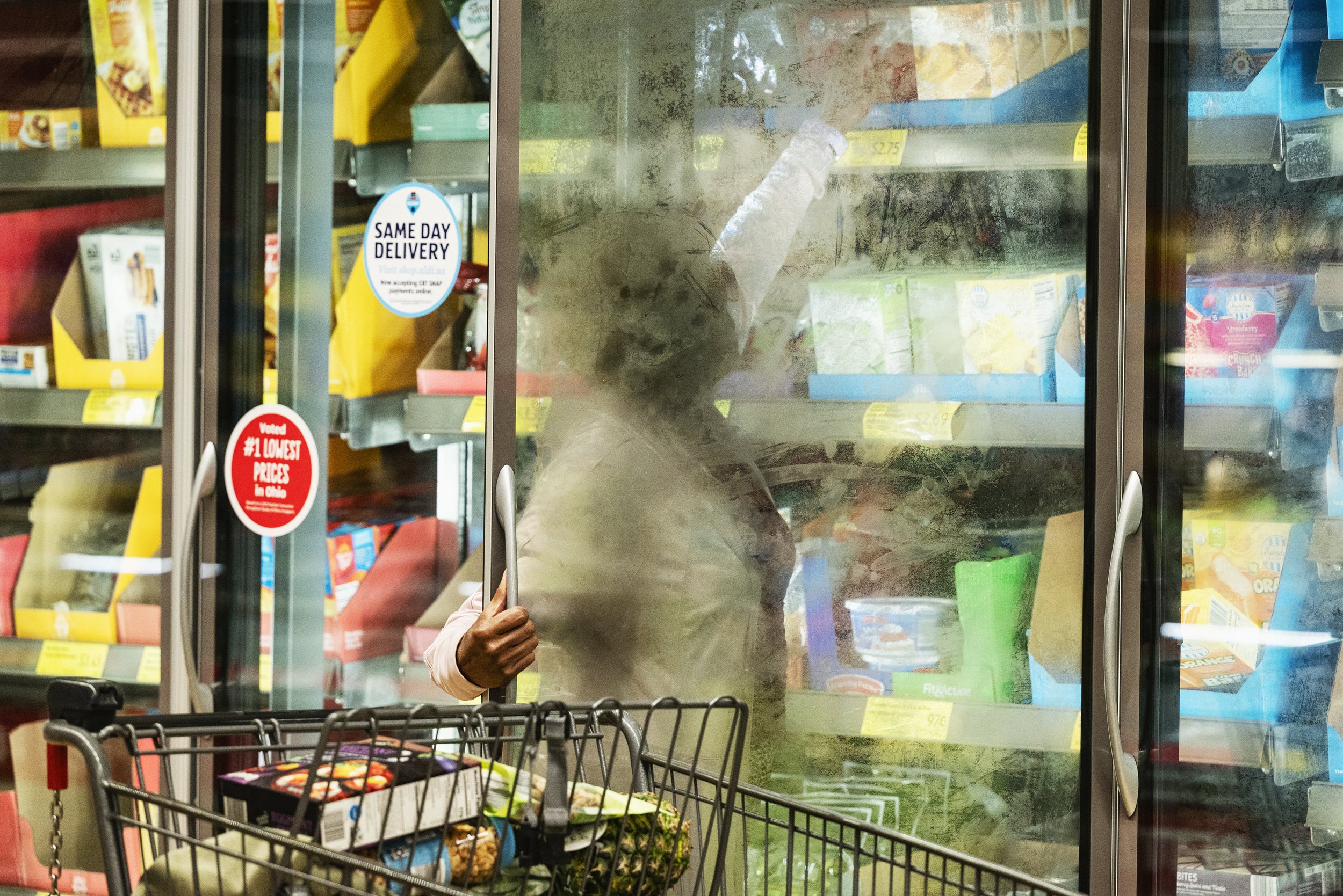  Dr. Tee Ford-Ahmed reaches into a freezer while browsing frozen food items at Aldi supermarket in Athens, Ohio, Saturday April 15, 2023.  