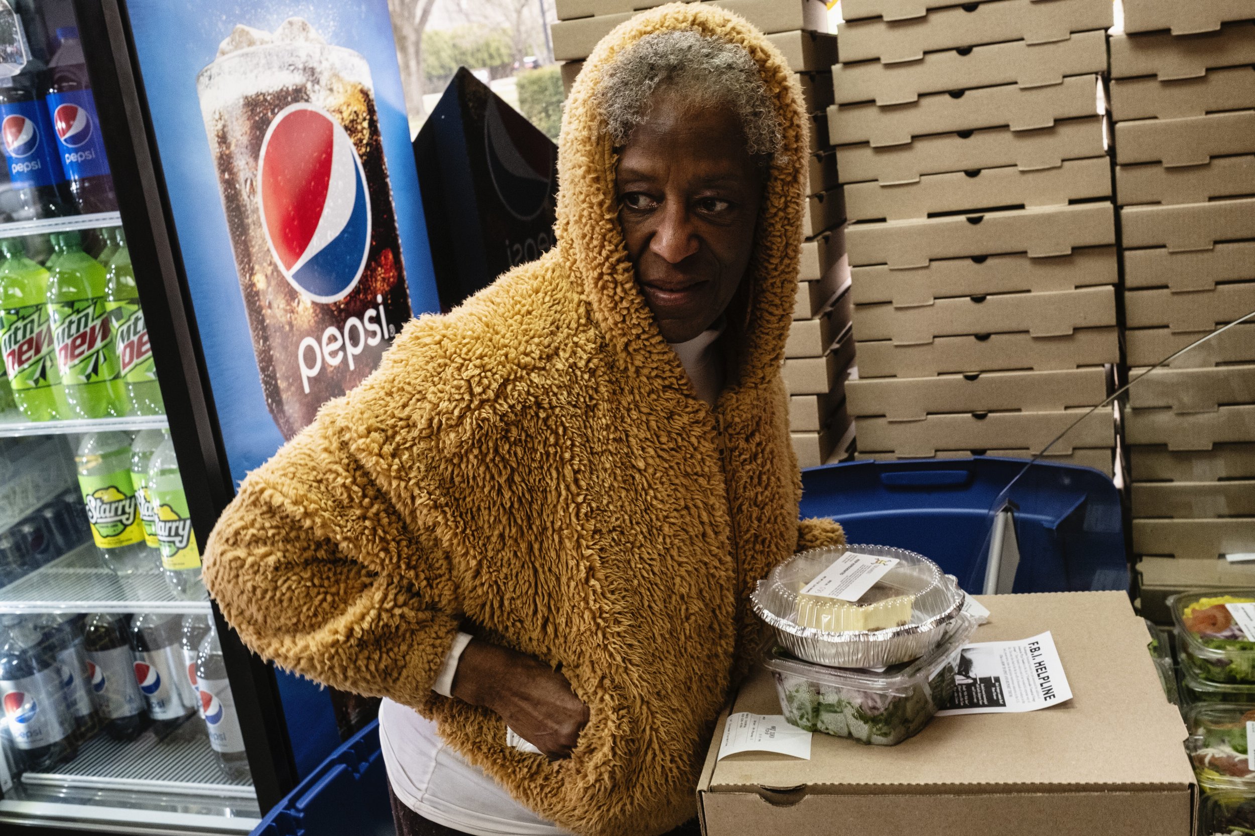  Dr. Tee Ford-Ahmed sneaks in extra sauce packets while picking up her lunch order at Avalanche Pizza in Athens, Ohio, Saturday March 18, 2023.  