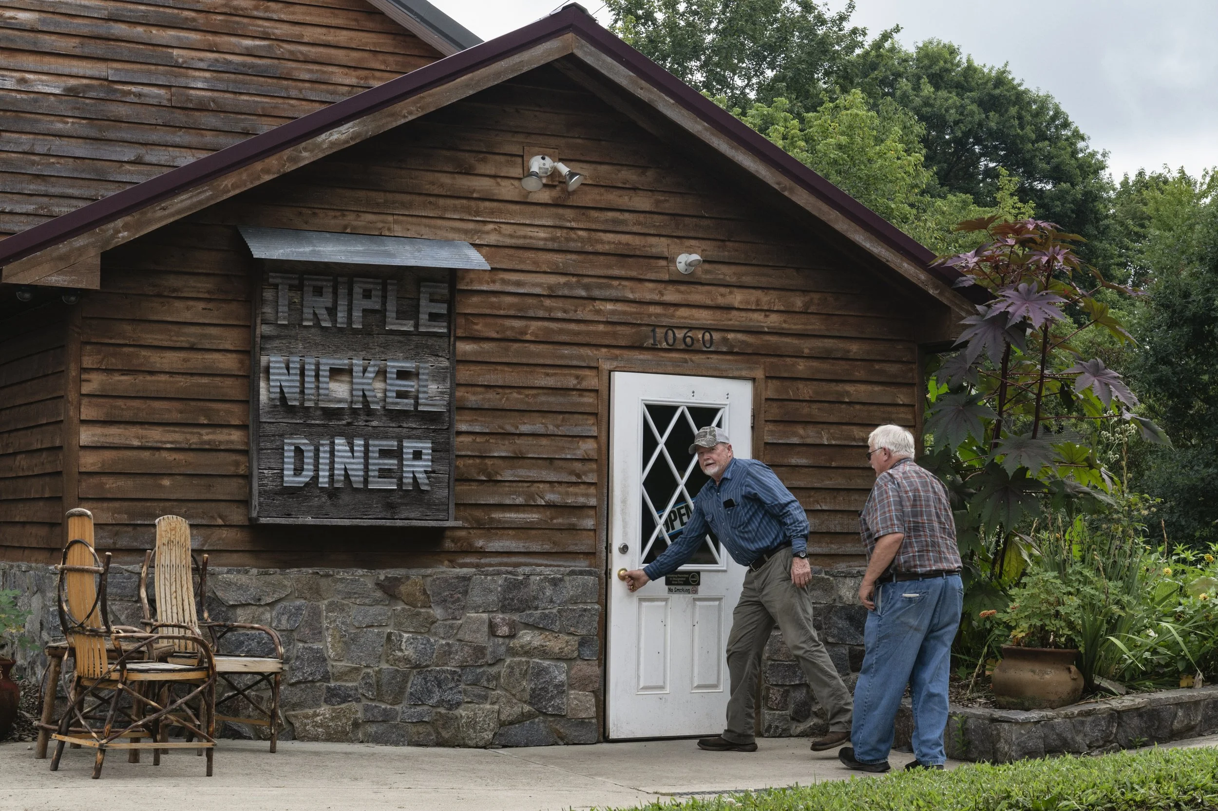  Stanley Strode, right, the uncle of Triple Nickel Diner co-owner Rosie Berardi, arrives with his friend Bob Stout for breakfast in Chesterhill, Ohio, on Saturday, Aug. 13, 2025. Strode, a farmer who specializes in pork production, supplies the diner