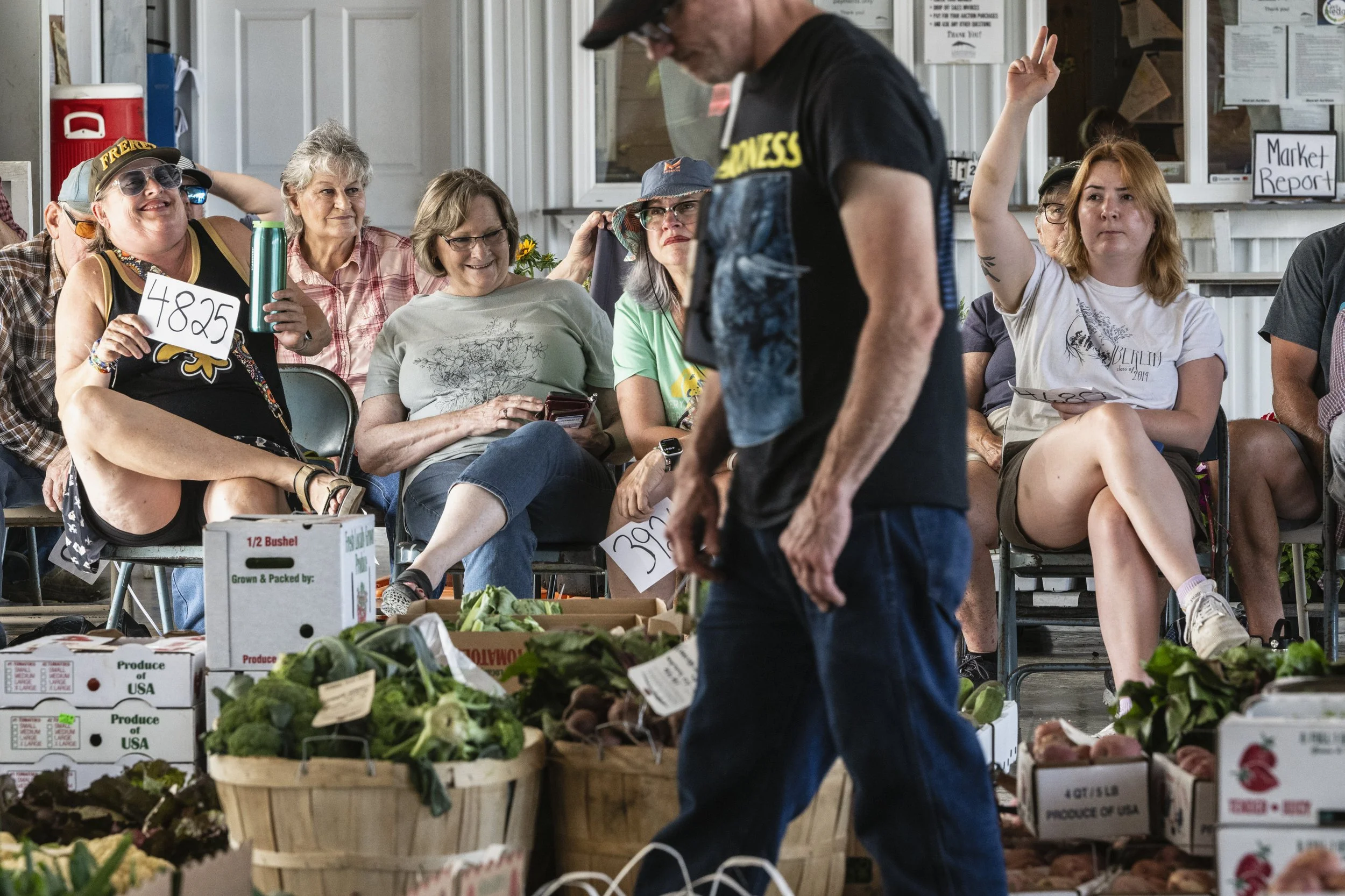  People react while bidding for fresh produce at the Chesterhill Produce Auction in Chesterhill, Ohio, on Thursday, June 12, 2025. Founded in 2004 by Jean and Marvin Konkle, the auction began under a tent the following year to connect local growers w